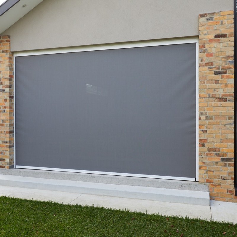 Grey outdoor zip screen lowered across an opening between brick pillars