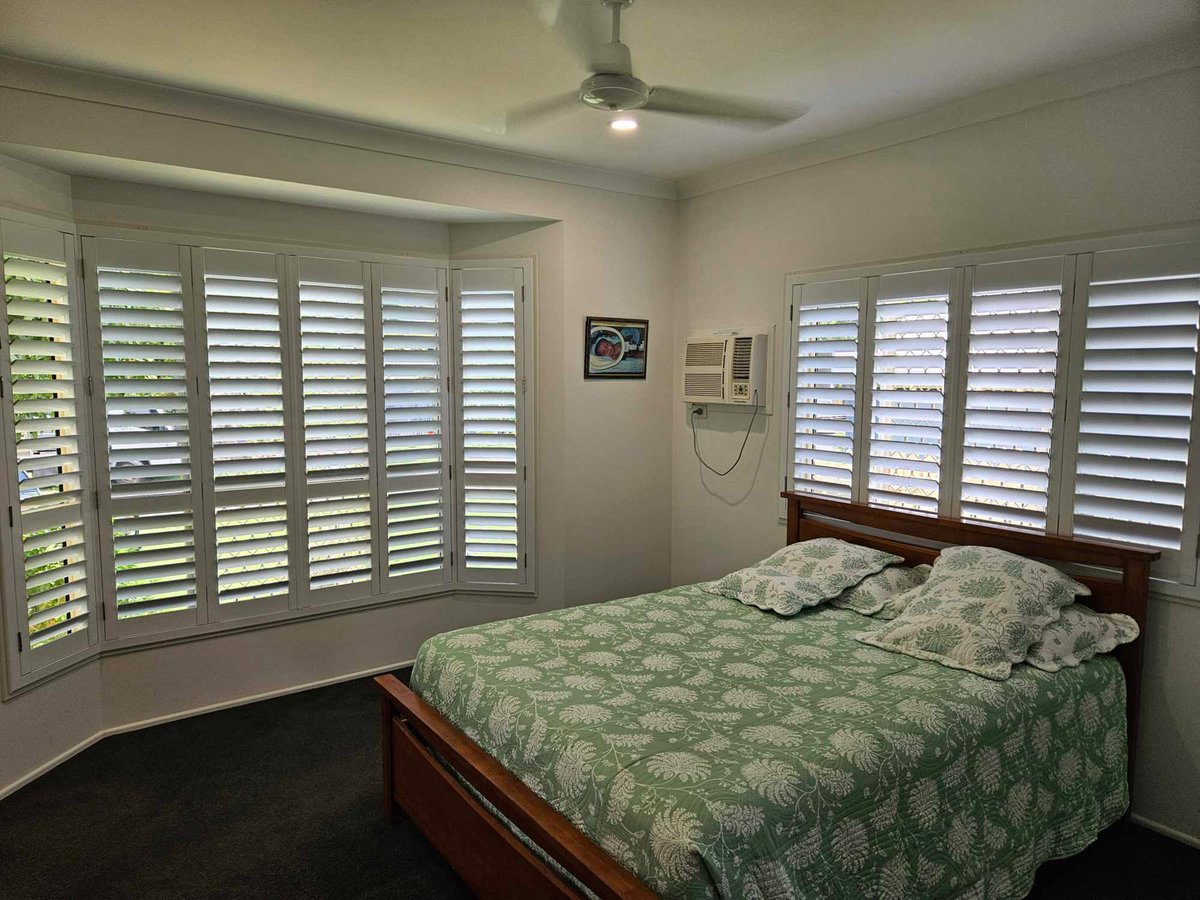 White plantation shutters on a bedroom bay window